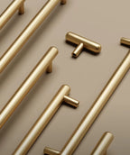 Gold cabinet handles arranged on a beige background