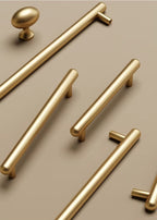 Set of gold cabinet handles on a beige background